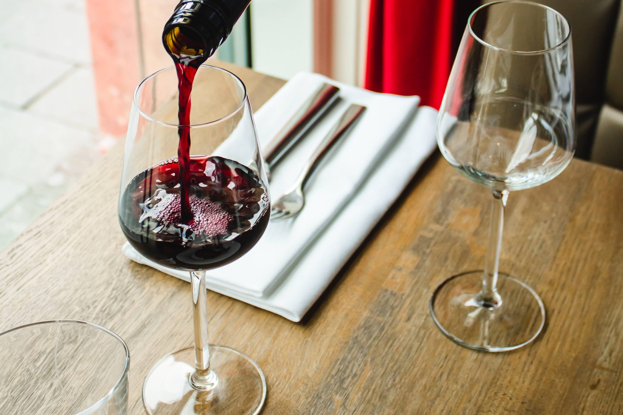 pouring red wine into glass